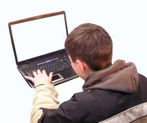 Home Tiener aan gamebureau met meerdere schermen voor gaming en huiswerk