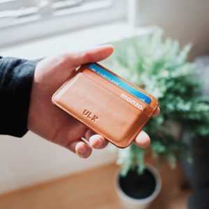 Uitschuifbare pasjeshouder in leer met creditcards en betaalpassen georganiseerd