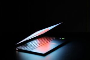 Persoon kiest de juiste laptop tussen HP Pavilion en Lenovo modellen op werkbureau
